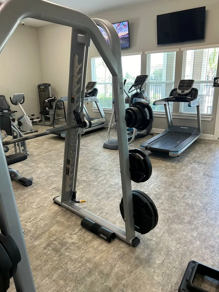 Clean Smith machine and other fitness equipment in an apartment complex clubhouse gym