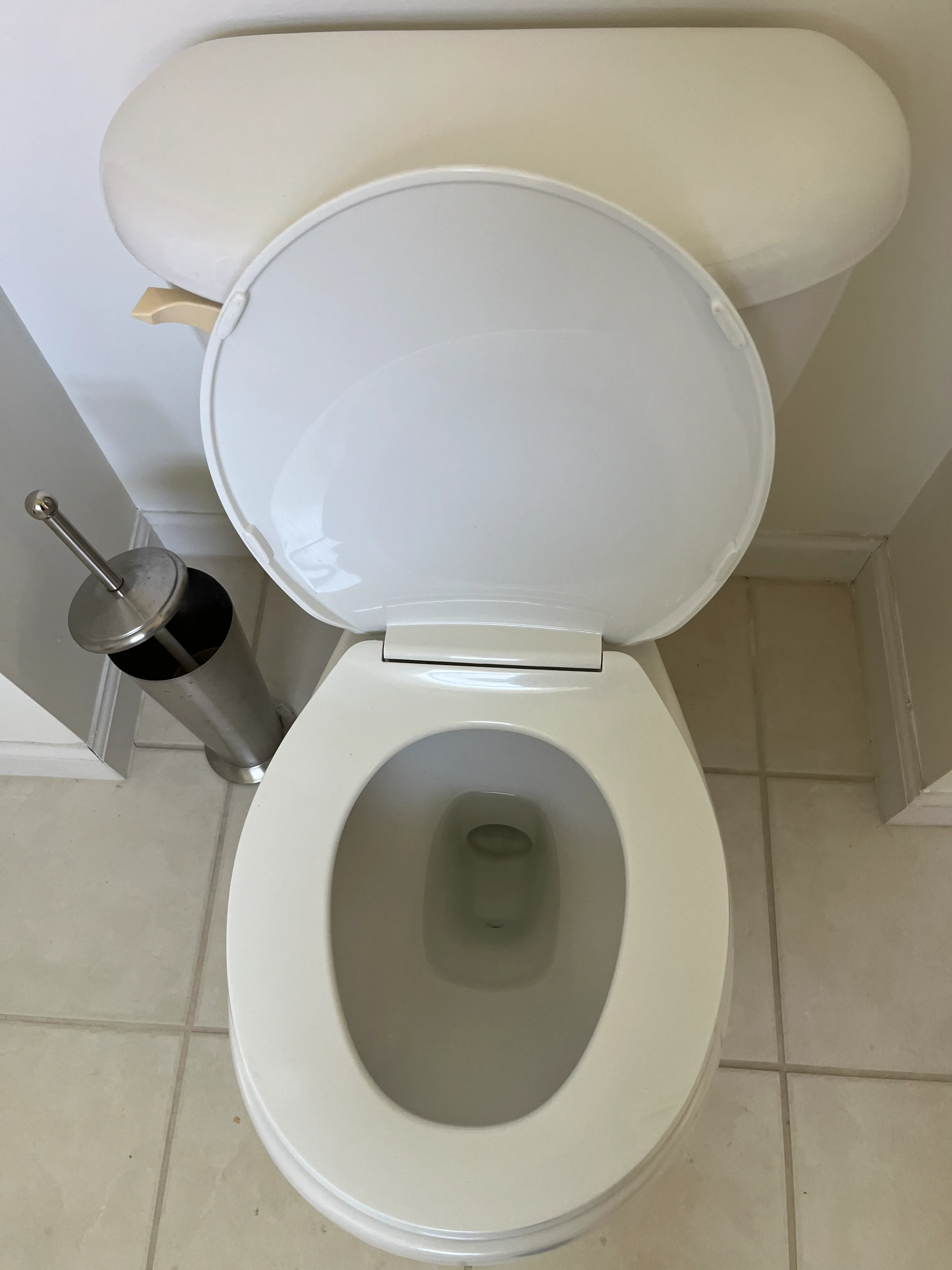 Standard toilet in a clean residential bathroom with tiled floors