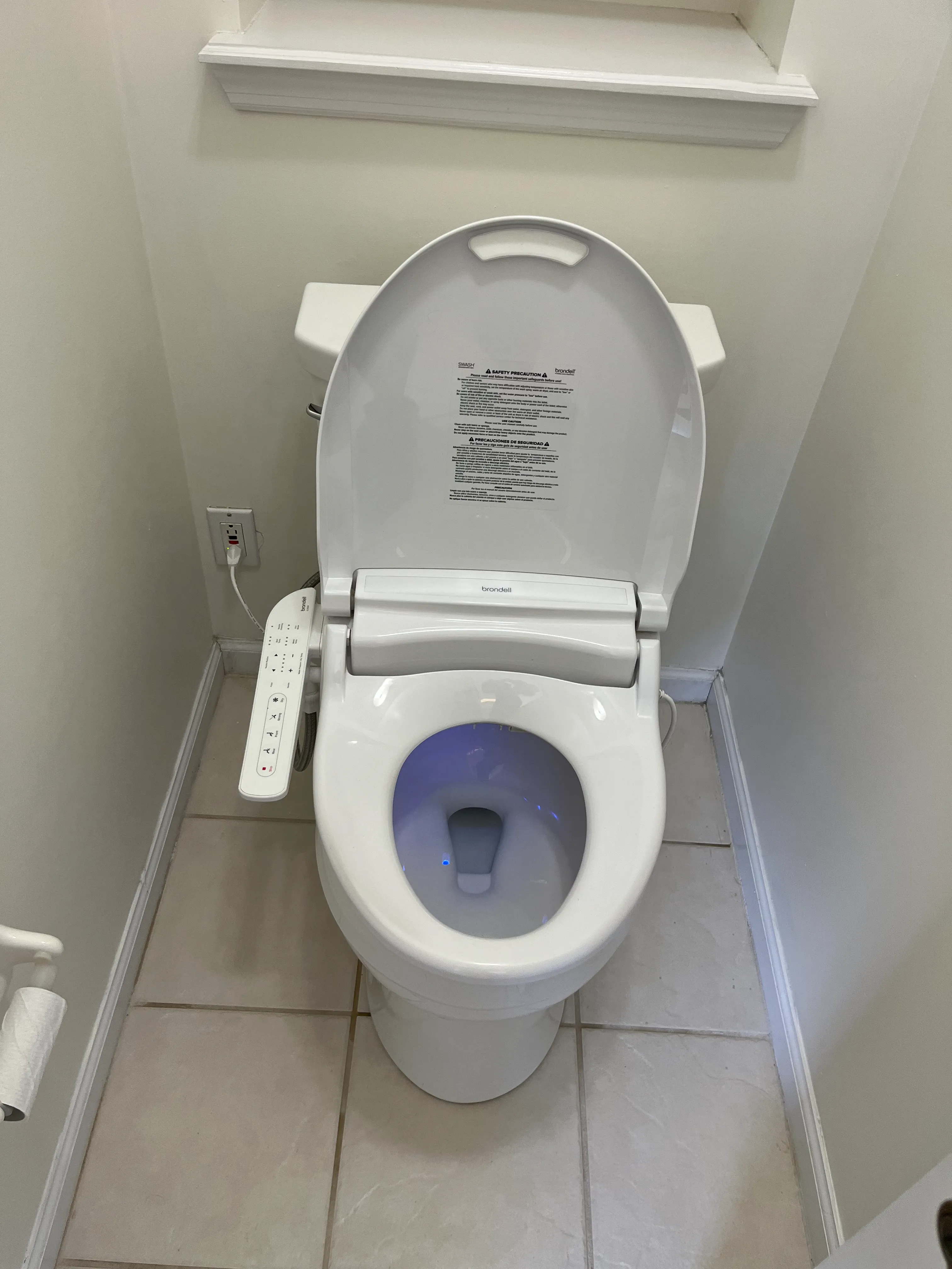 Clean residential bathroom with a modern bidet-style toilet and tiled floor